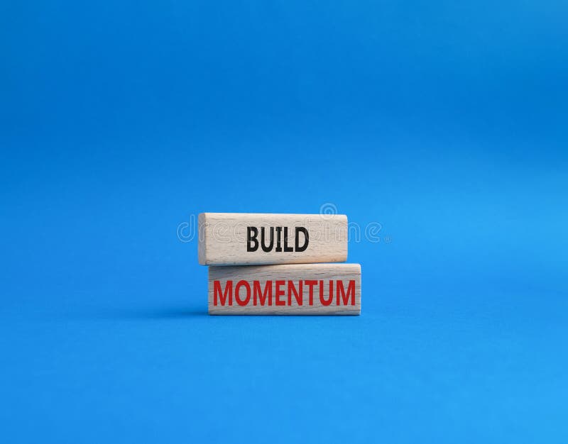 Build momentum symbol. Wooden blocks with words Build momentum. Beautiful blue background. Business and Build momentum concept. stock photography