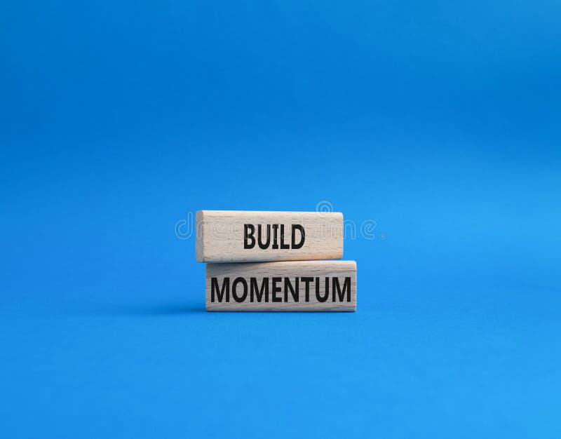 Build momentum symbol. Wooden blocks with words Build momentum. Beautiful blue background. Business and Build momentum concept. royalty free stock image