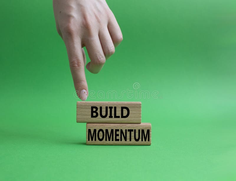 Build momentum symbol. Wooden blocks with words Build momentum. Beautiful green background. Businessman hand. Business and Build royalty free stock photos