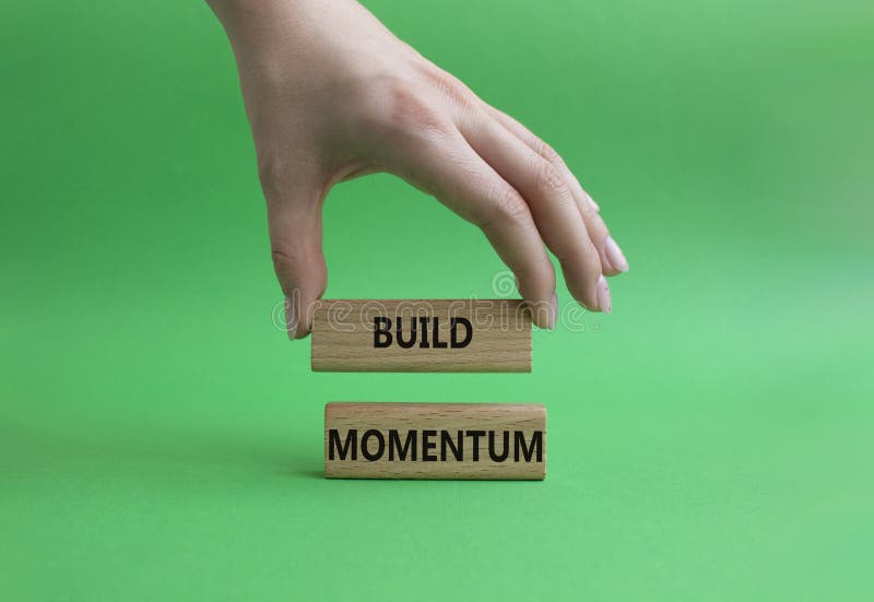 Build momentum symbol. Wooden blocks with words Build momentum. Beautiful green background. Businessman hand. Business and Build momentum concept. Copy space