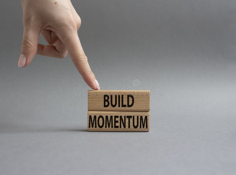 Build momentum symbol. Wooden blocks with words Build momentum. Beautiful grey background. Businessman hand. Business and Build royalty free stock images