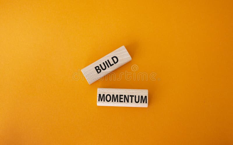 Build momentum symbol. Wooden blocks with words Build momentum. Beautiful orange background. Business and Build momentum concept. royalty free stock image