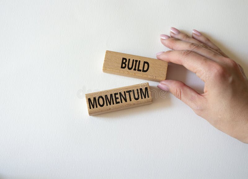 Build momentum symbol. Wooden blocks with words Build momentum. Beautiful white background. Businessman hand. Business and Build royalty free stock photo
