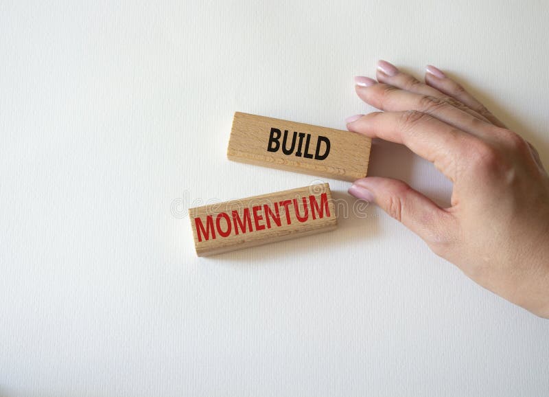 Build momentum symbol. Wooden blocks with words Build momentum. Beautiful white background. Businessman hand. Business and Build royalty free stock photo