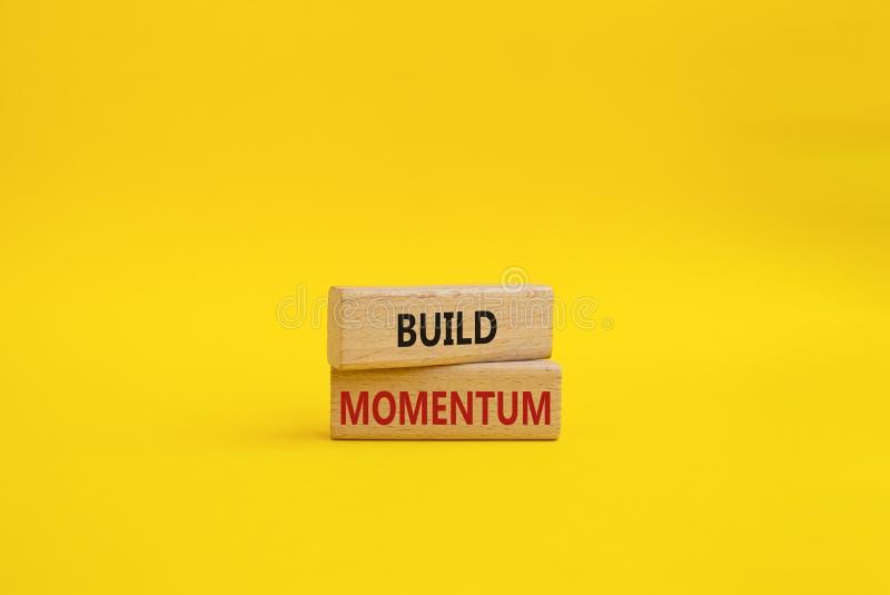 Build momentum symbol. Wooden blocks with words Build momentum. Beautiful yellow background. Business and Build momentum concept. royalty free stock photography