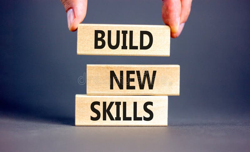 Build new skills symbol. Concept word Build new skills on beautiful wooden block. Businessman hand. Beautiful grey table grey royalty free stock photo