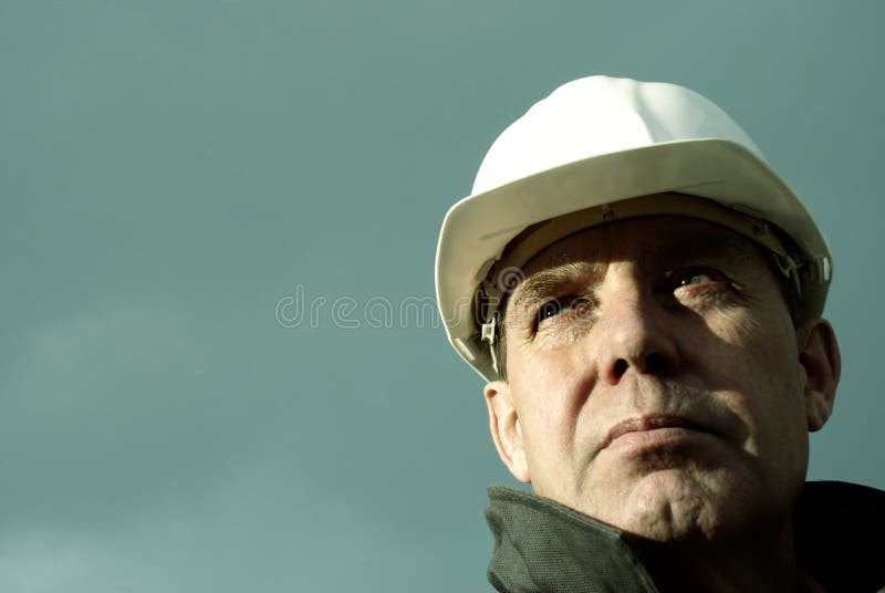 Man with white hard hat, special photo toned f/x, focus point on the eye. Quality special stock images, royalty-free photos and pictures