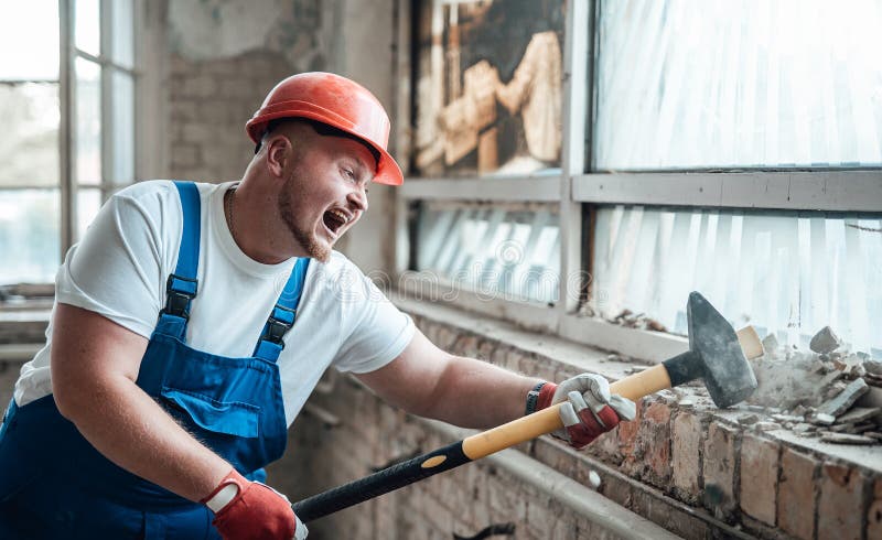 Builder at the construction site, smashing walls with a hammer, screaming