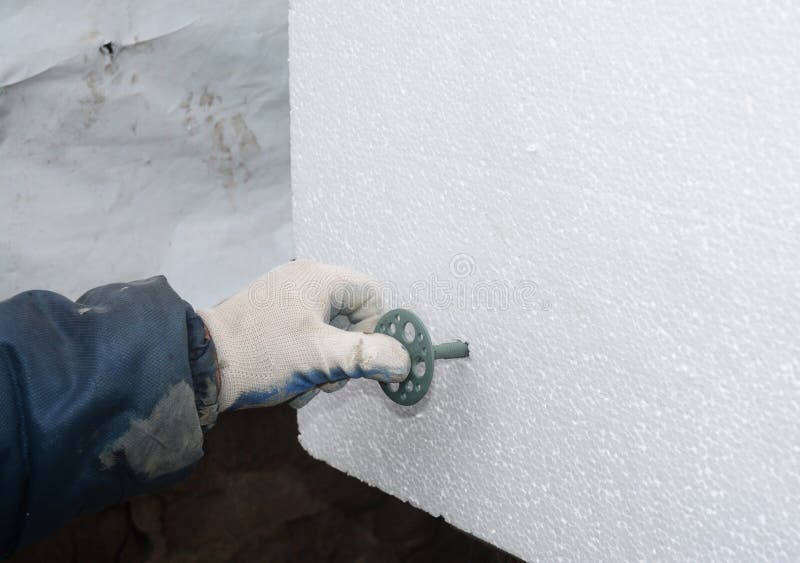 Builder Hand Installing Rigid Styrofoam Insulation Board with Plastic