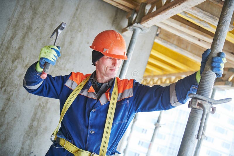 Builder installing or dismantling pole support for concrete monolithic formwork at housebuilding stock image Builder installing or dismantling pole support for concrete monolithic formwork at housebuilding stock image