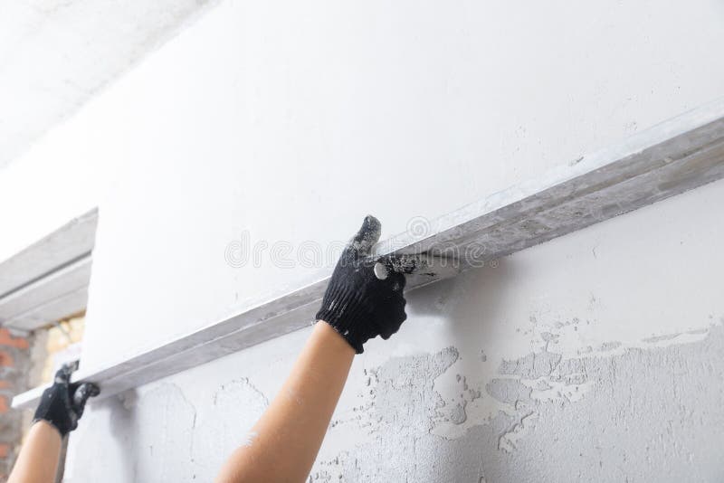 Builder Level out defects in concrete walls with cement plaster.