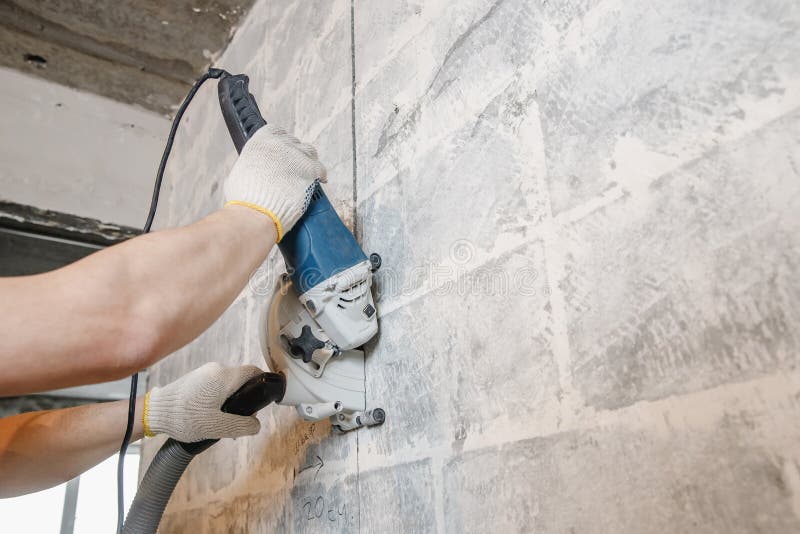 Builder Man Cutting Electrical Chase in Concrete Wall with Groove