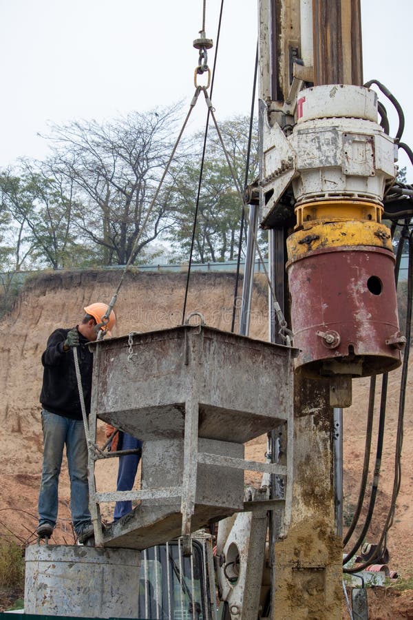 Builder Pours Concrete into the Foundation Formwork at the Construction