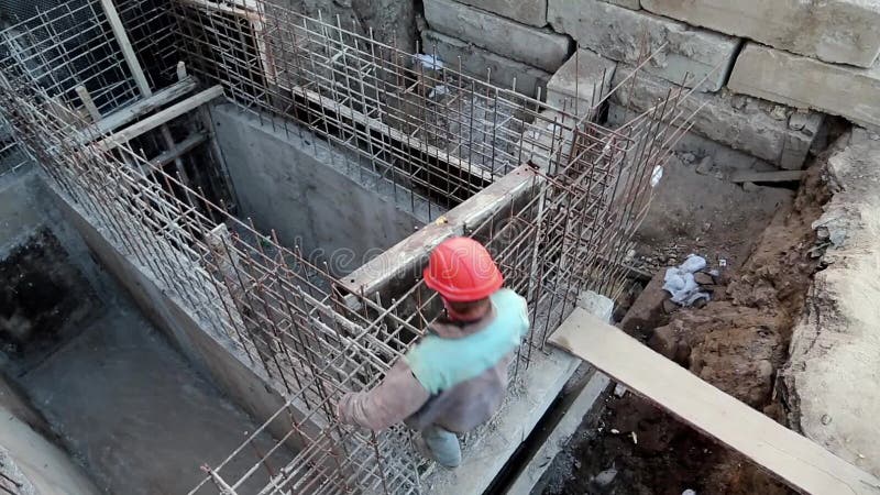 Builder with red hard hat at project site. Building of foundation