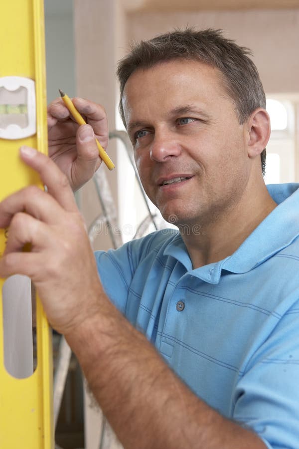 Builder Using Spirit Level On Wall