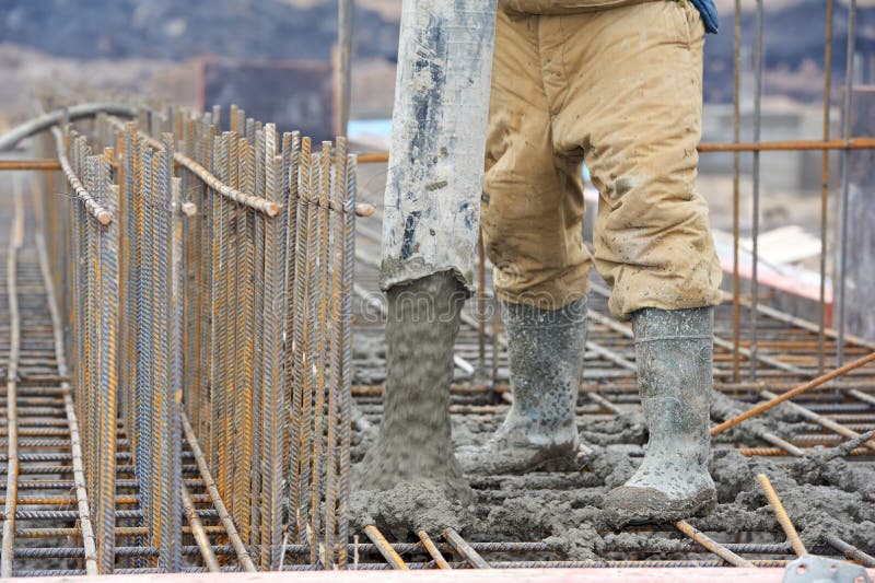 Builder worker pouring concrete into form