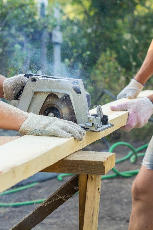 The Builders Cuts the Board with a Circular Saw Stock Photo Image of