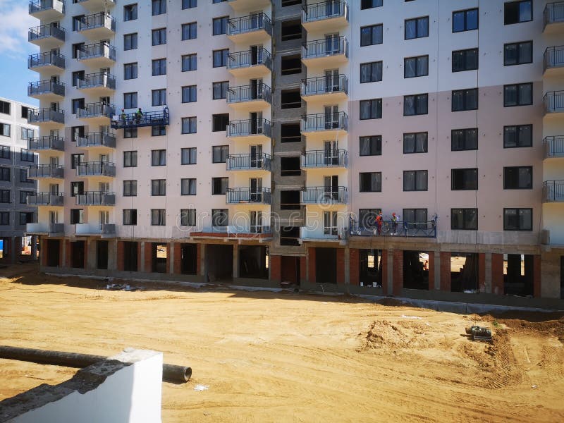 Builders Paint the Facade of an Apartment Building. Construction of