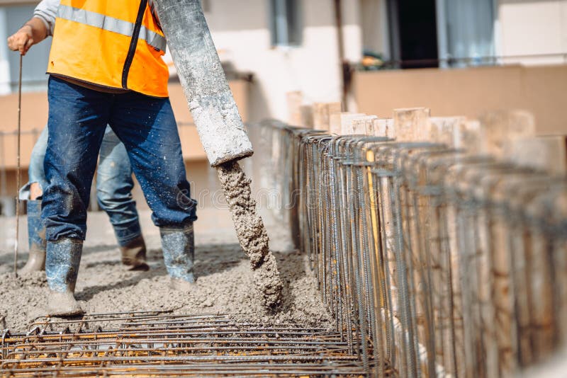 construction site details - building concrete slabs at house construction and pouring cement on reinforcement bars