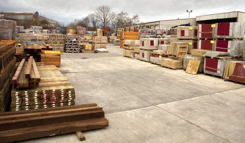 A yard at a builders merchants full of paving slabs, blocks and cut timber. A yard at a builders merchants full of paving slabs, blocks and cut timber.