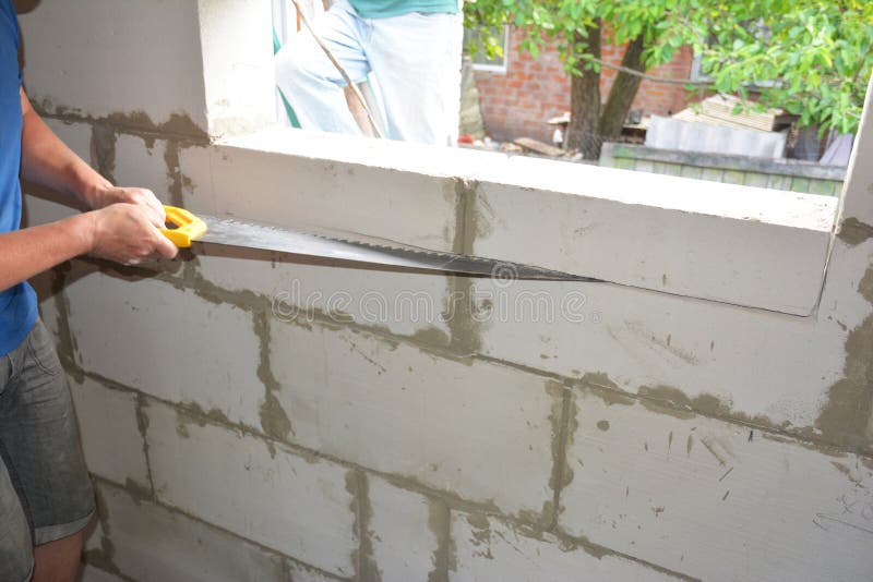 A Building Contractor is Cutting the Wall with a Masonry Brick Block