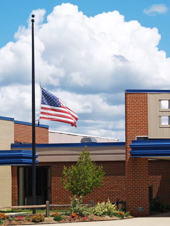 A flag flying half mast over a brick building. A flag flying half mast over a brick building