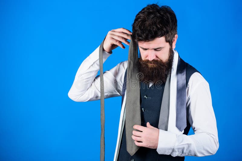 Building his necktie wardrobe. Bearded man choosing a necktie of his wardrobe. Stylish mens wardrobe for business or formal occasions. Wardrobe essentials having a timeless appeal, copy space.