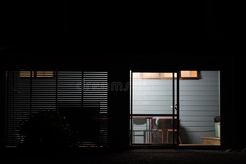 Building Wall Horizontal Lines Behind Glass Door with Table and Chairs