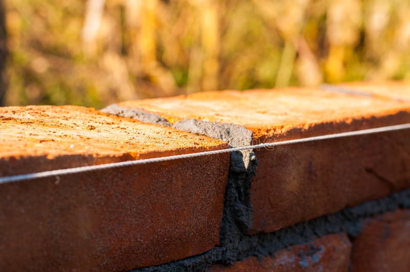 Building a Wall with Red Brick. Working with Bricks for Building a Wall