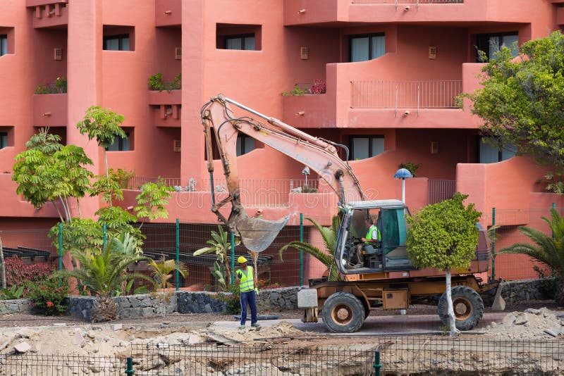 Building work noise next to hotel rooms, Costa Adeje, Tenerife. TENERIFE, CANARY ISLANDS - May 17, 2018. Bulldozer digging, building work making noise and stock image Building work noise next to hotel rooms, Costa Adeje, Tenerife. TENERIFE, CANARY ISLANDS - May 17, 2018. Bulldozer digging, building work making noise and stock image