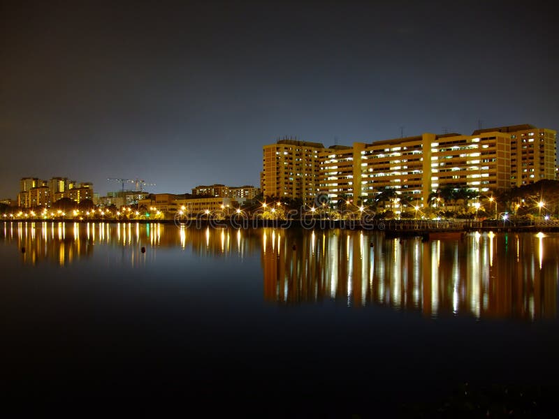 Buildings by Pandan reservoir under blue night sky