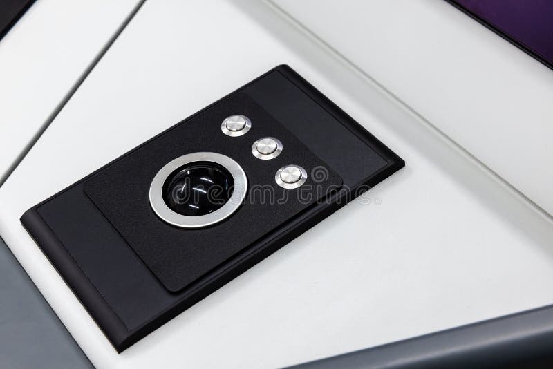 Built-in tabletop input device, trackball mouse close up photo. Built-in tabletop input device, trackball mouse is a pointing device consisting of a ball held by a socket containing sensors to detect a rotation of the ball about two axes