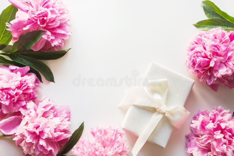 Bukett av den rosa pionen i vas med gåvan på vit Kopiera utrymme f?r text dagblomman ger m?drar mumsonen till ovanf?r sikt arkivbilder Bukett av den rosa pionen i vas med gåvan på vit Kopiera utrymme f?r text dagblomman ger m?drar mumsonen till ovanf?r sikt arkivbilder