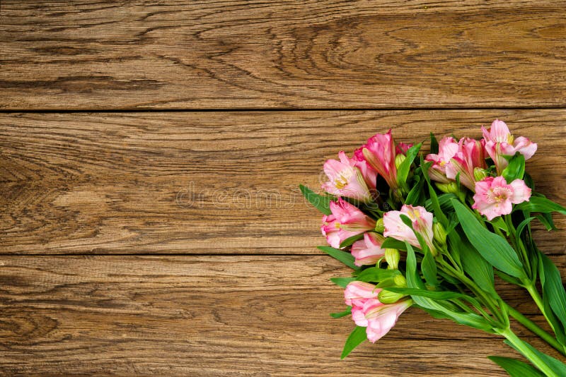 Bukett av rosa alstroemeria på träplattan fotografering för bildbyråer Bukett av rosa alstroemeria på träplattan fotografering för bildbyråer