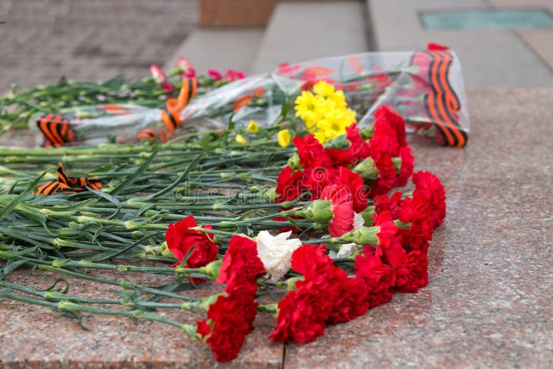 Buketter av blommor ligger på granitmoment på foten av monumentet i Victory Memorial under berömmen av Victory Day royaltyfria foton Buketter av blommor ligger på granitmoment på foten av monumentet i Victory Memorial under berömmen av Victory Day royaltyfria foton