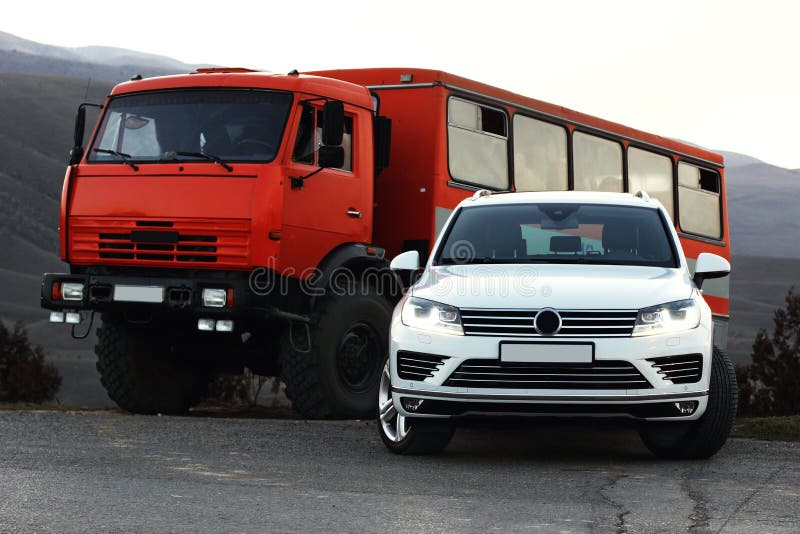 Bukharwhite SUV stands at the exit of the mountain road next to a large shift truck royalty free stock photos Bukharwhite SUV stands at the exit of the mountain road next to a large shift truck royalty free stock photos