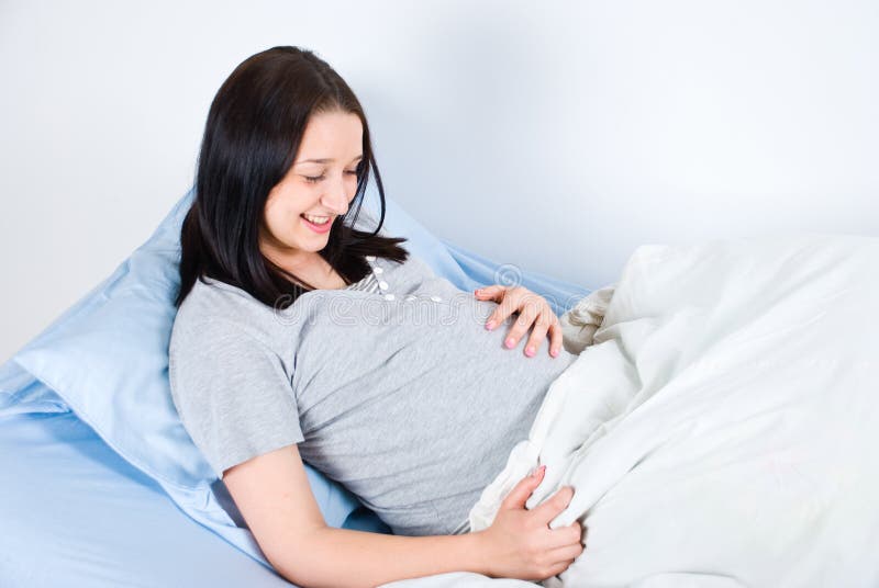 bukta lyckligt henne gravid trycka på royaltyfria bilder bukta lyckligt henne gravid trycka på royaltyfria bilder
