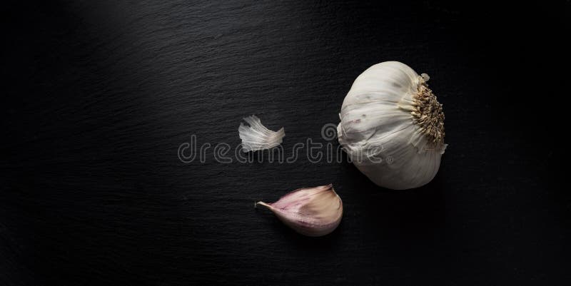 Bulbs of dried garlic on black slate surface royalty free stock photo Bulbs of dried garlic on black slate surface royalty free stock photo