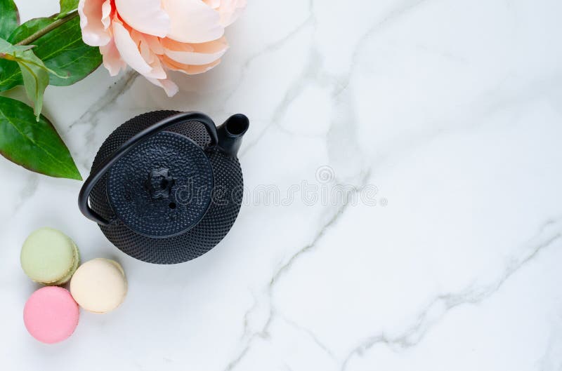 Bule e macarons com as flores no fundo de mármore Vista superior imagens de stock royalty free Bule e macarons com as flores no fundo de mármore Vista superior imagens de stock royalty free