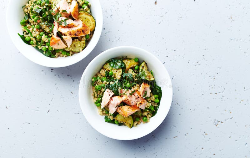 Bulgur with green vegetables and poached salmon. Healthy homemade meal. Flatlay. Copy space