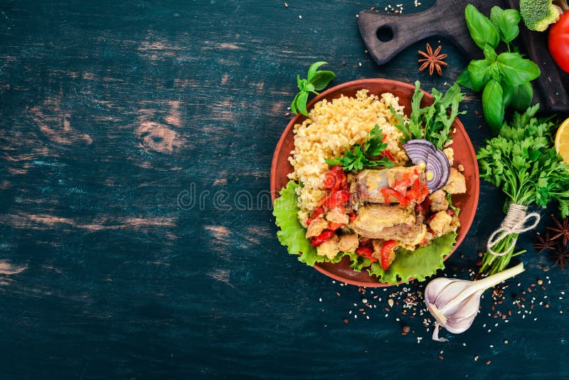 Bulgur with meat, paprika, cherry tomatoes, and vegetables. On a wooden background. royalty free stock photo Bulgur with meat, paprika, cherry tomatoes, and vegetables. On a wooden background. royalty free stock photo