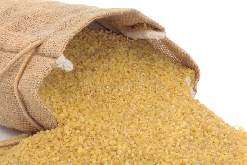 Bulgur wheat spilling out from a hessian sack, over white background.