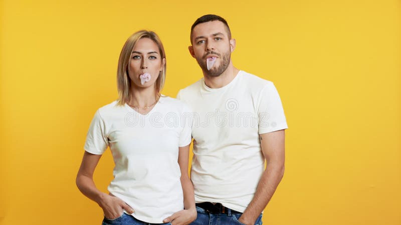 Bulles de soufflage de jeunes couples avec le chewing-gum banque de vidéos