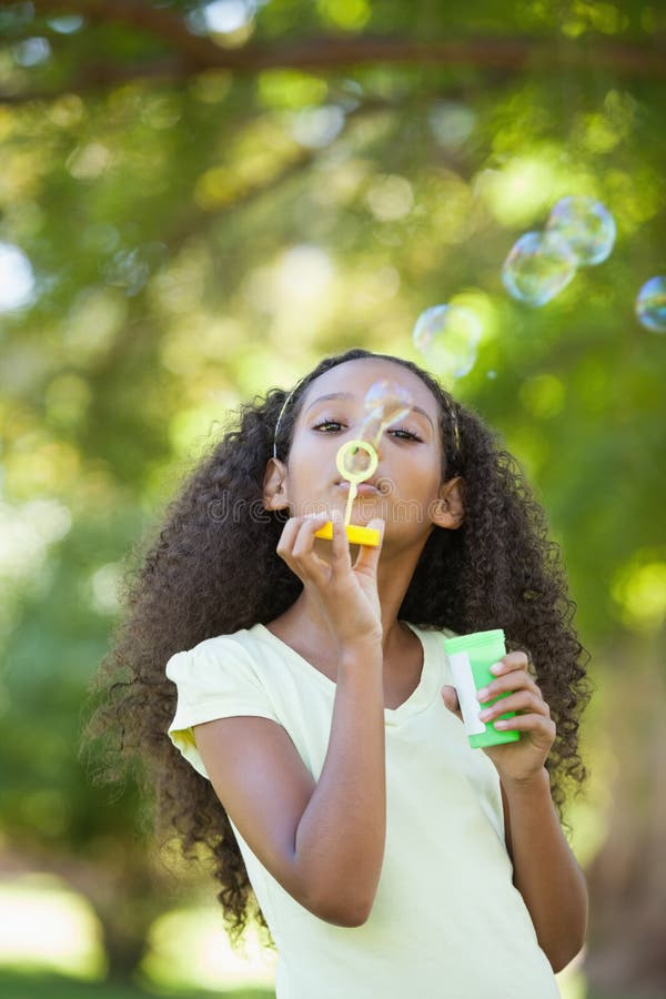 Bulles de soufflement de jeune fille en parc image libre de droits