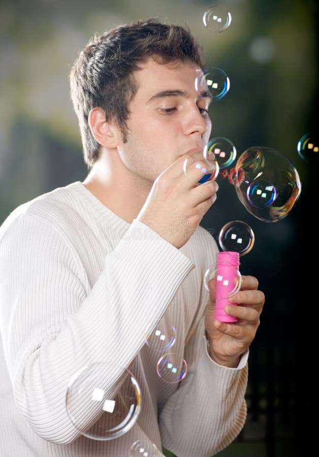 Bulles de soufflement de jeune homme photographie stock libre de droits Bulles de soufflement de jeune homme photographie stock libre de droits
