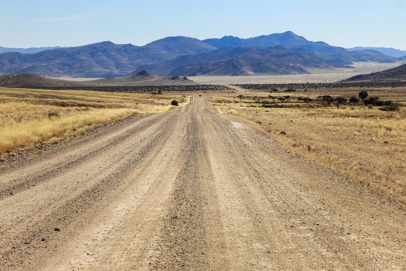 Bumpy road to mountains and through dry desert grassland.