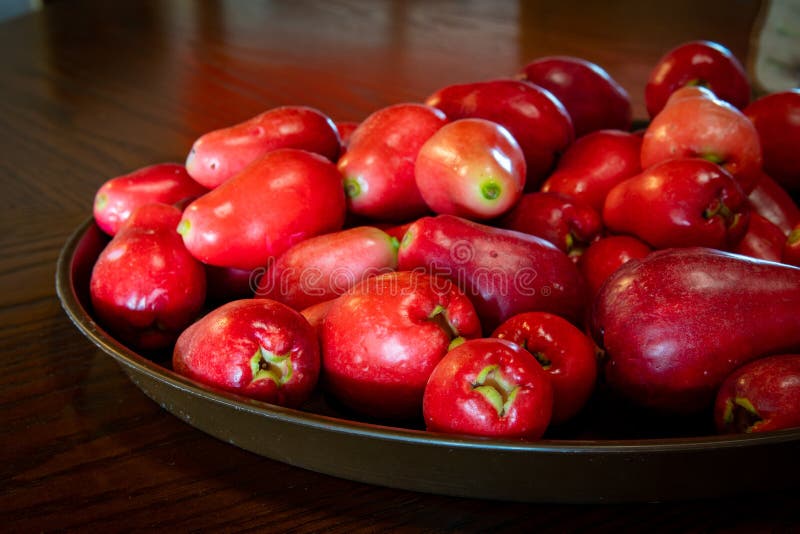 Bunch of fresh ripe red skin Jamaican Otaheite apples. Popular tangy flavor fruit in Jamaica & the Caribbean culture. Healthy organic vegetarian vegan food with one single large seed and white flesh.