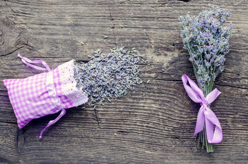 Bunch of lavender flowers and sachet filled with dried lavender on a wooden background. Top view.