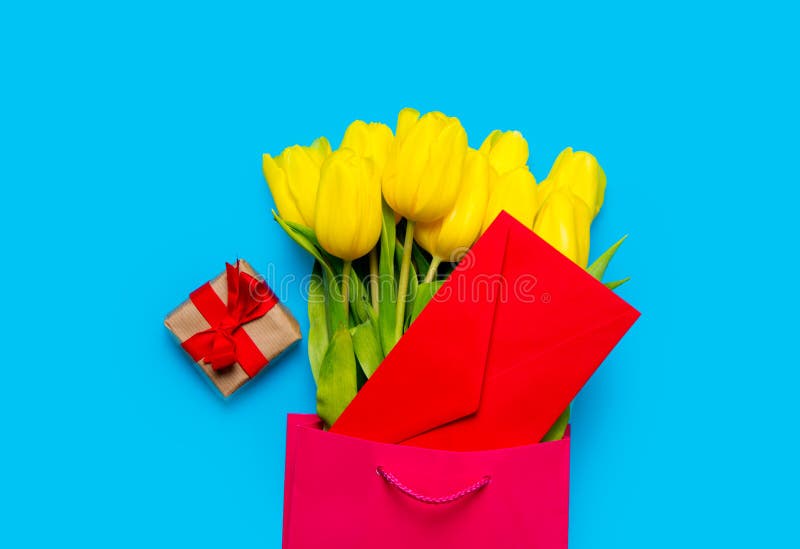 Bunch of yellow tulips and red envelope in cool shopping bag and stock photography Bunch of yellow tulips and red envelope in cool shopping bag and stock photography
