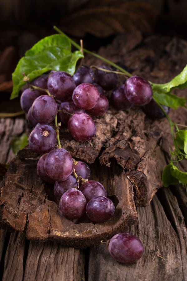 Bunches of fresh ripe red grapes on a wooden textural background royalty free stock photos